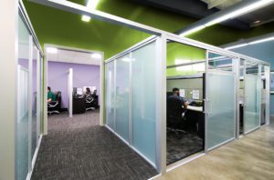 People working in their frosted glass divided working booth