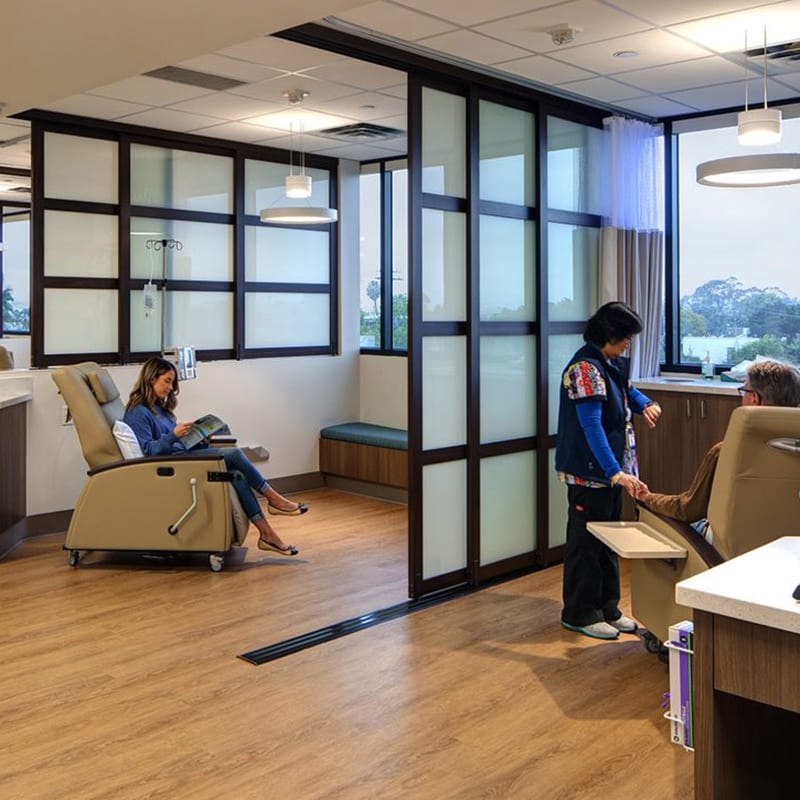 People are waiting for checkup in medical offices divided by glass sliding doors