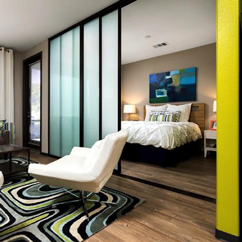 Hotel bedroom and living area divided by frosted glass sliding door