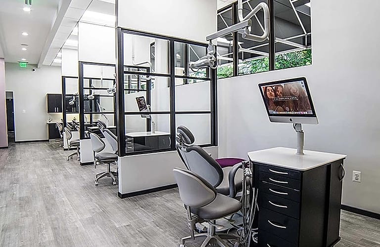 Row of modern orthodontics offices separated metal framed fixed glass panels