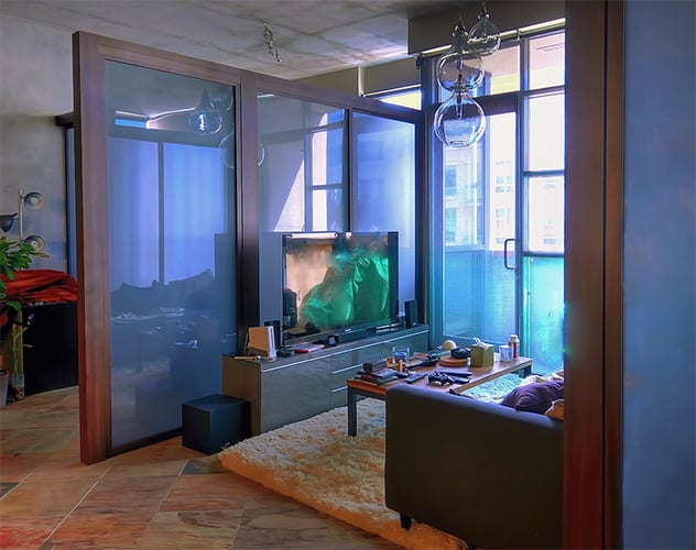Wood framed glass privacy partition separates living room area