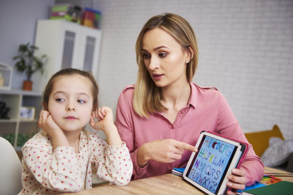 bored girl her mother studying with laptop home virtual learning