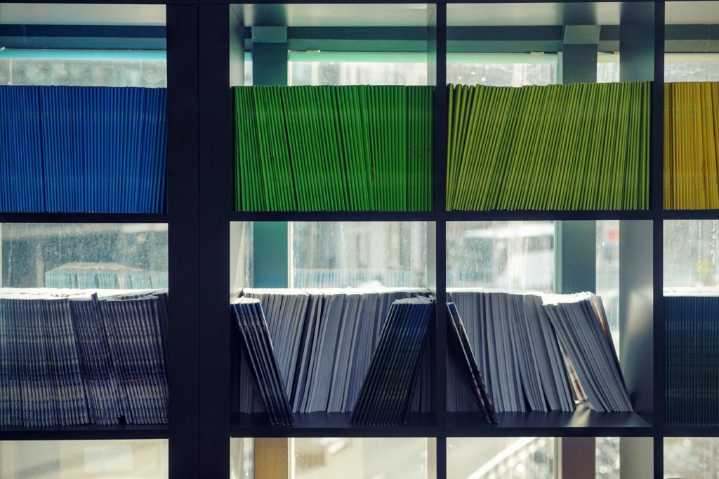 a series of bookshelves with colored folders