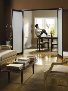 man sitting at dining table behind swing doors 