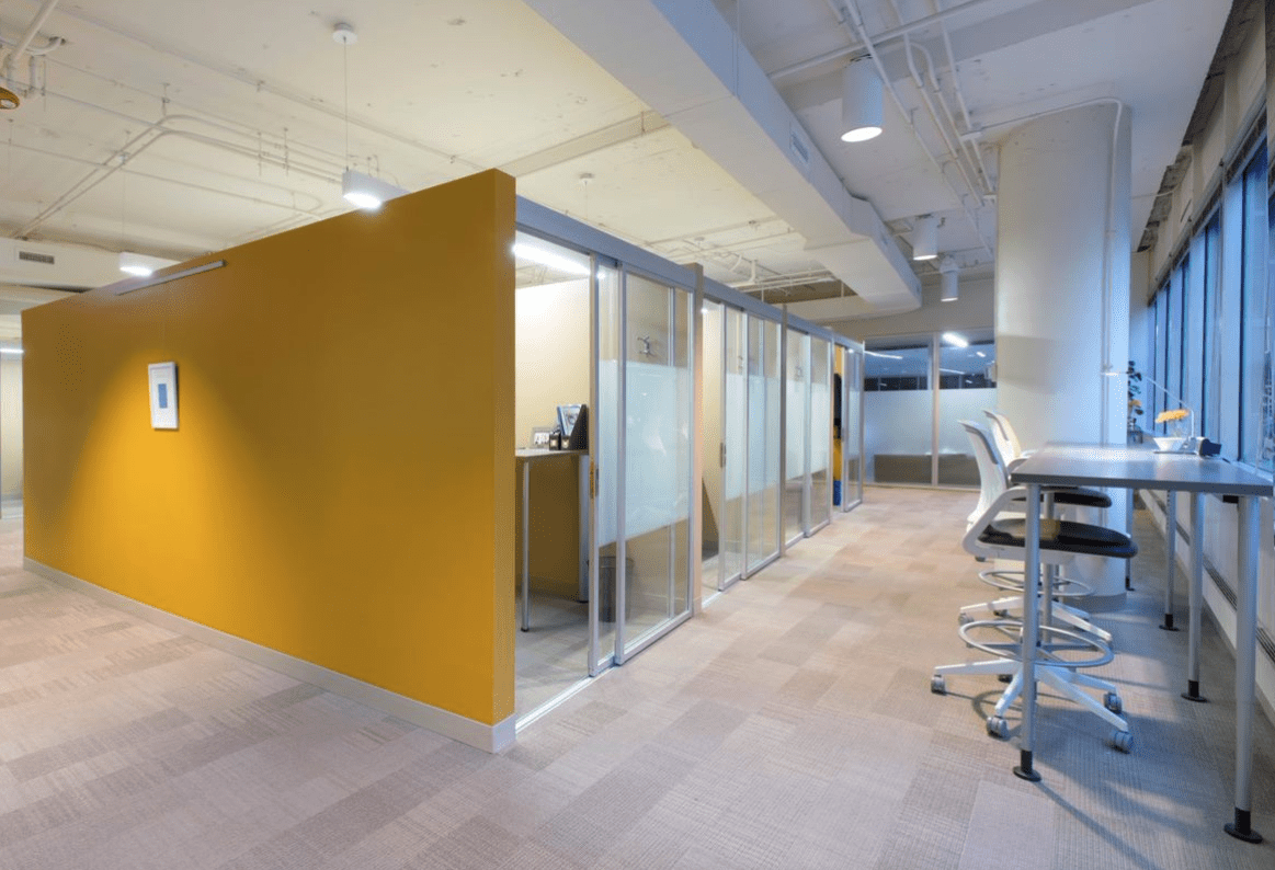Coworking space with glass sliding room dividers for private offices