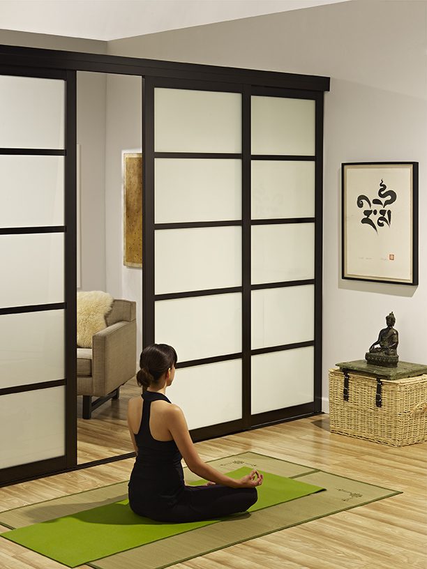 Girl meditating next to interior sliding frosted door