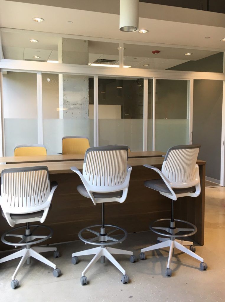 Half frosted glass partition wall divides meeting room space 